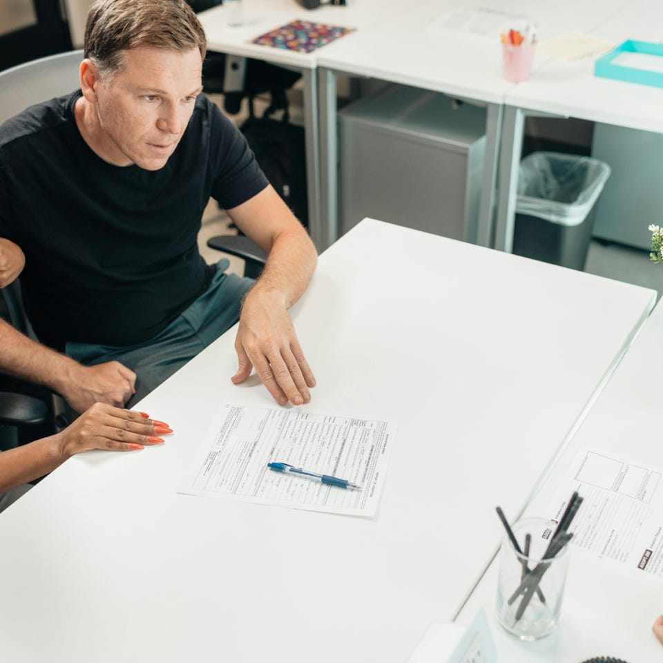 A couple discusses legal documents with a professional in a modern office setting.